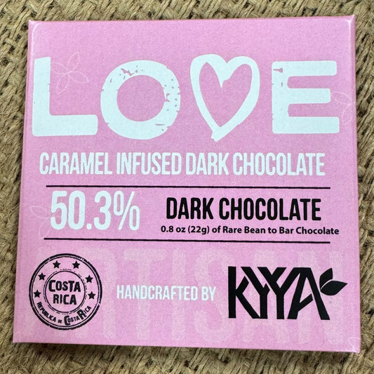 Pink chocolate bar packaging with 'LOVE' and 'KYYA' branding on a textured surface.